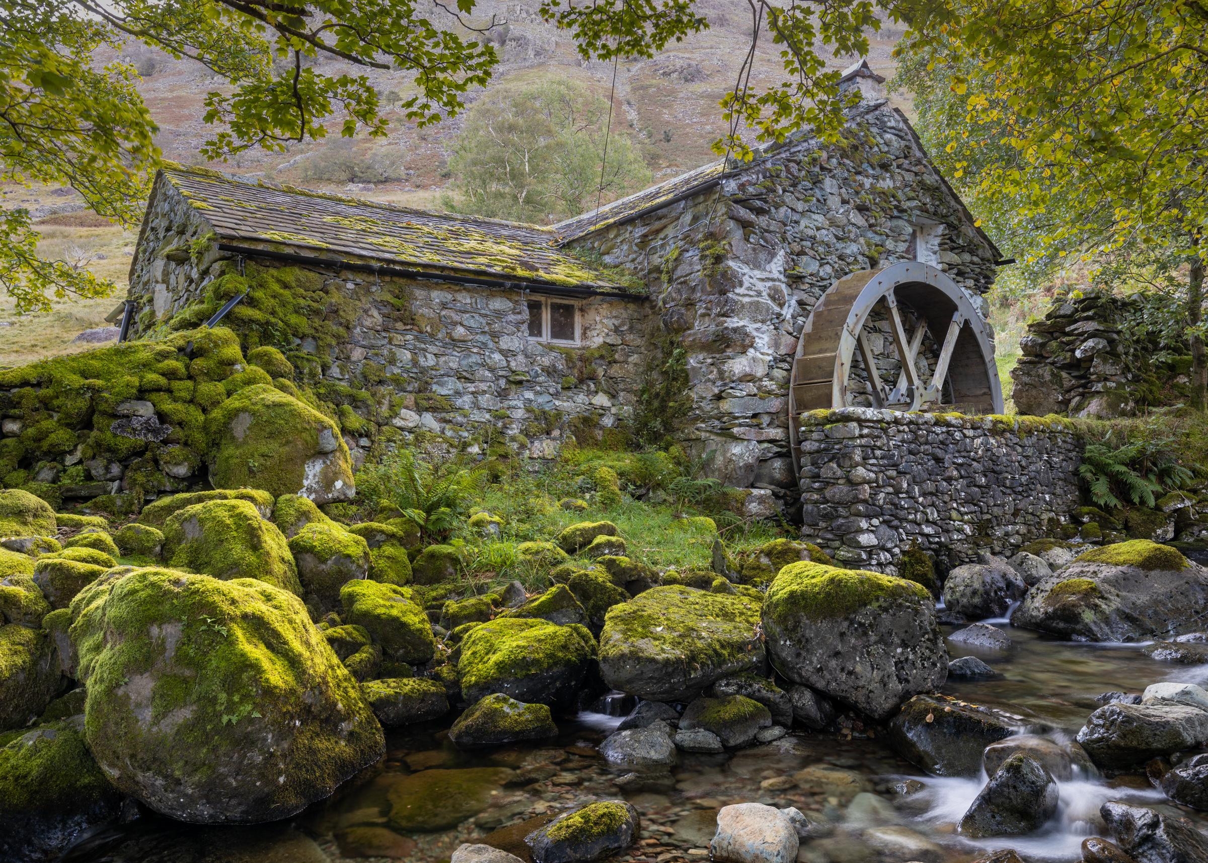 Borrowdale Water Mill in very early autumn with the diffused light coming over the nearby ridge providing a soft back light