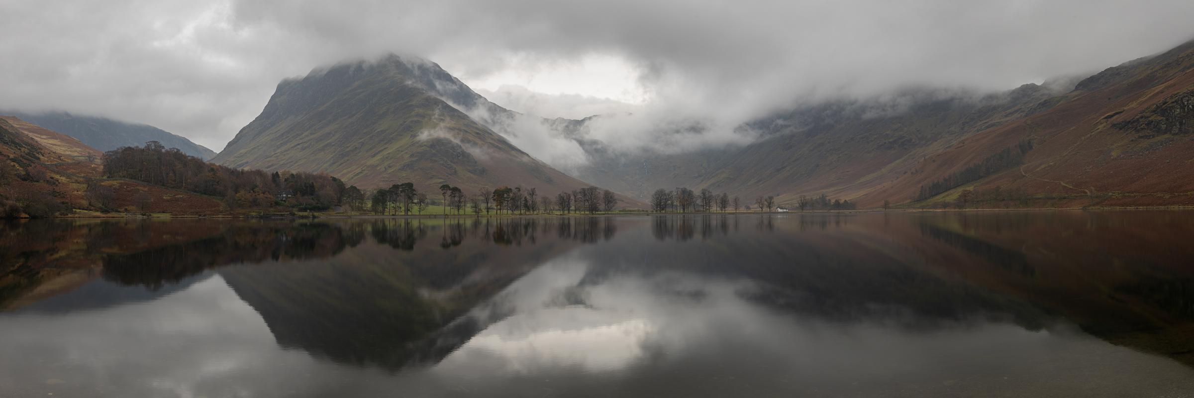 Panoramic shot of the Buttermere Pines with cloud rolling down the side of Fleetwith Pike and Warnscale.  I was drawn to this common scene by the way the clouds hugged and flowed over the flank of Fleetwith Pike.
