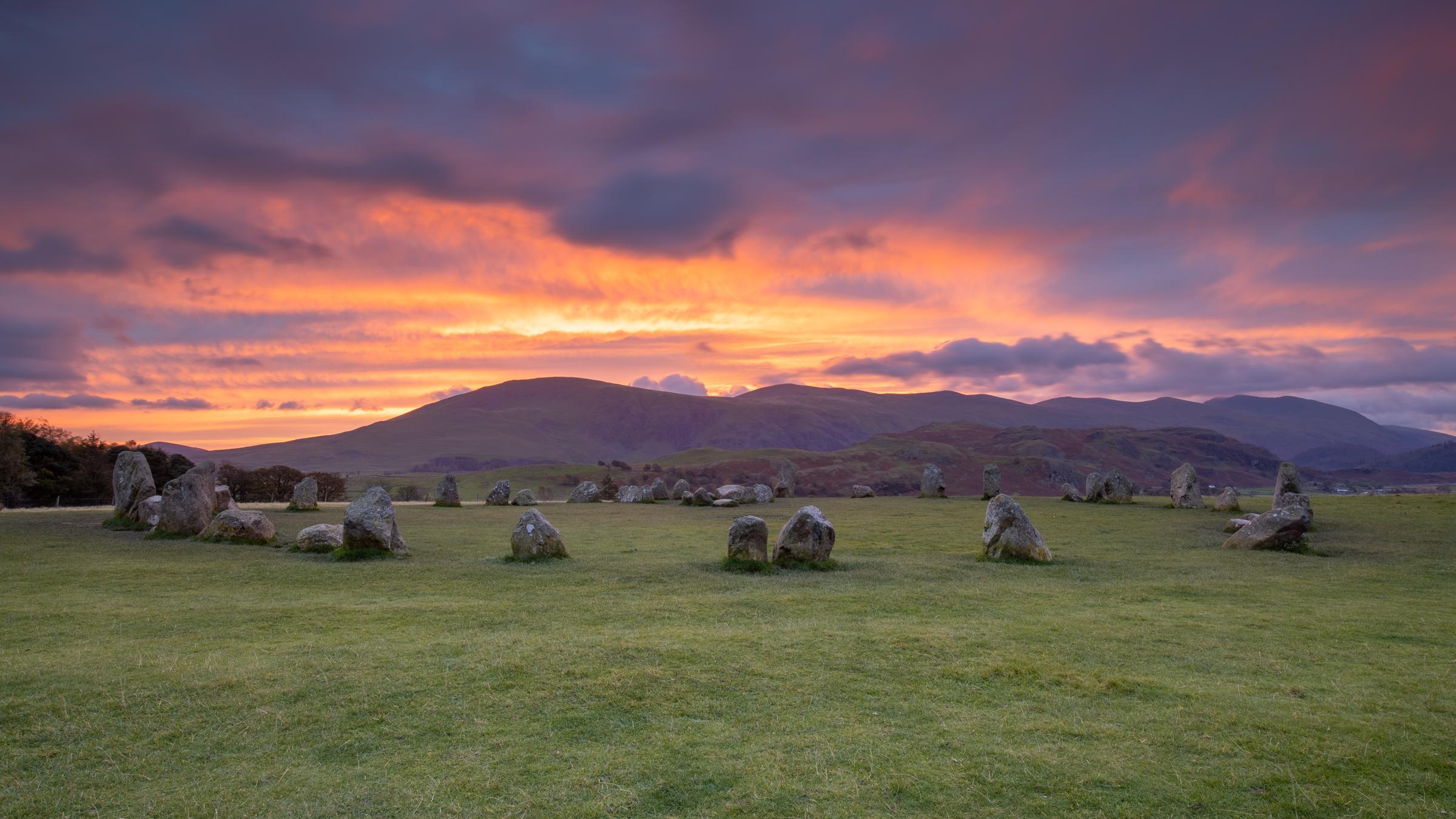 Autumnal dawn light explodes in the sky in a blanket of fire over the Helvellyn range at Castlerigg Stone Circle in the Lake District.  Its easy to wonder what Neolithic man must have thought at the sight of such wonders.